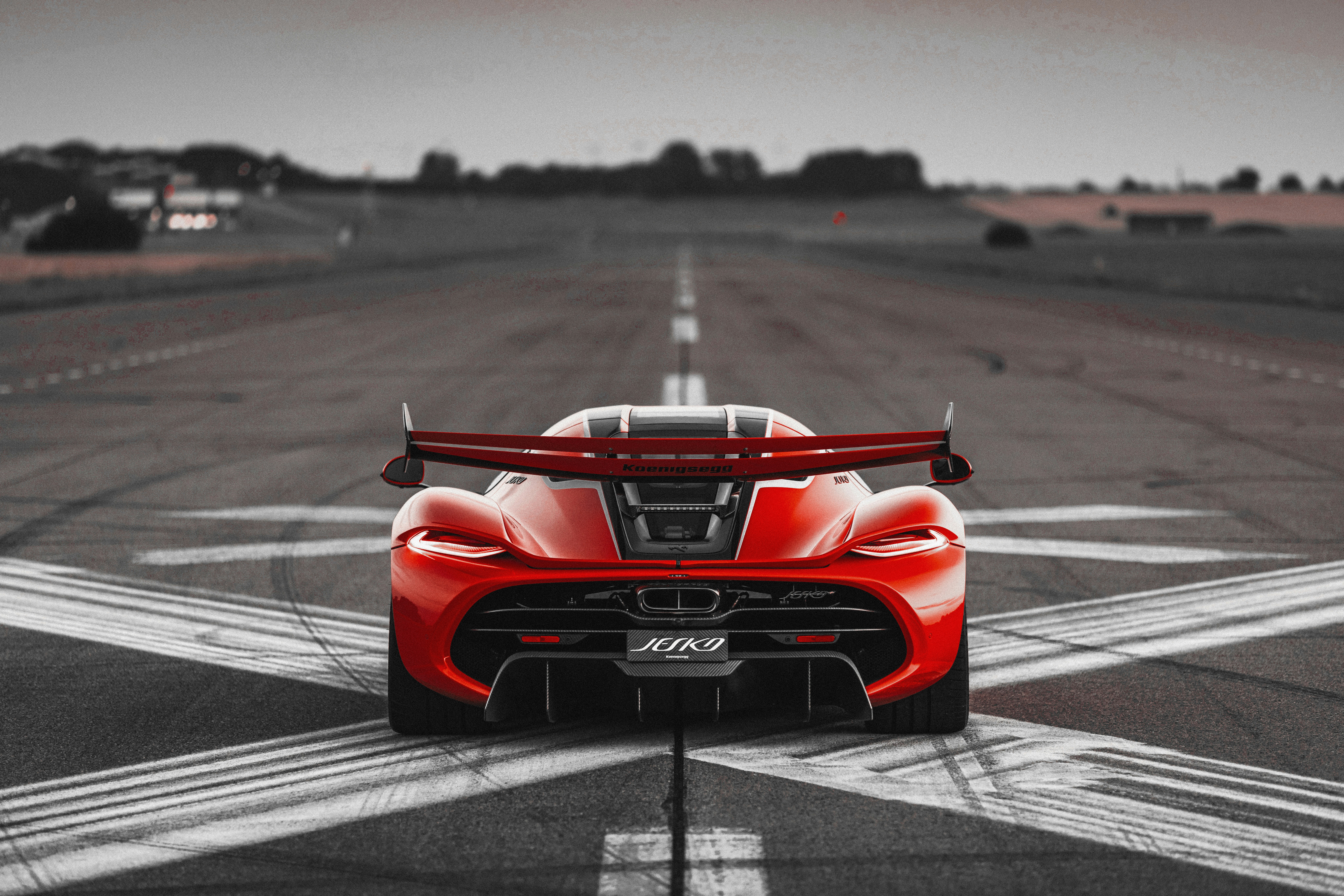 Koenigsegg Jesko, rdeč, pogled od zadaj na stezi — nebo v zgornji tretjini kadra